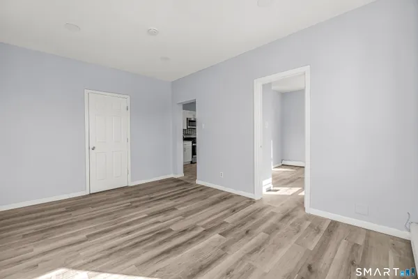 a view of an empty room with wooden floor