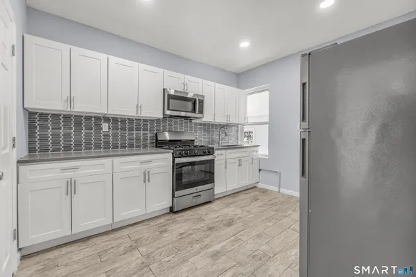 a kitchen with white cabinets stainless steel appliances and sink