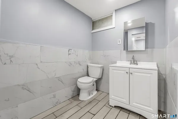 a bathroom with a toilet a sink and mirror