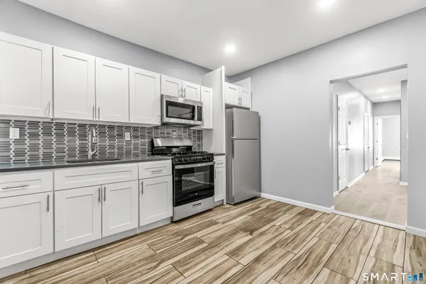 a kitchen with a refrigerator stove and white cabinets