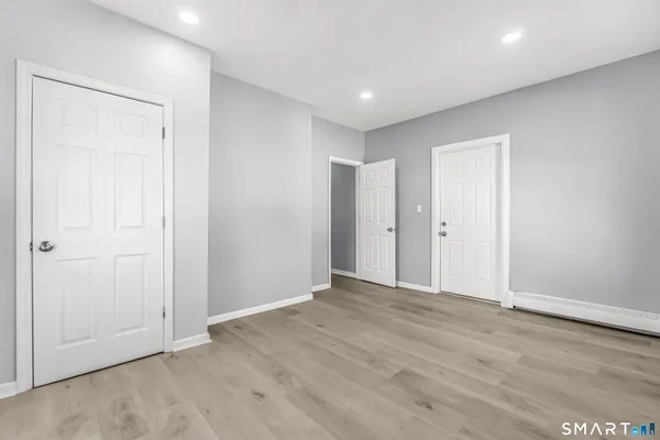 a view of an empty room with wooden floor