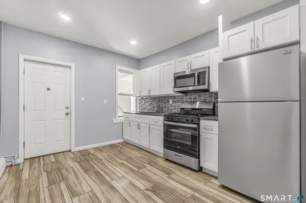 a kitchen with granite countertop a refrigerator stove and microwave