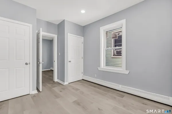 an empty room with a window and closet