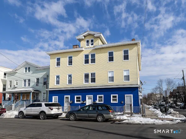 a front view of a residential apartment building with parking space