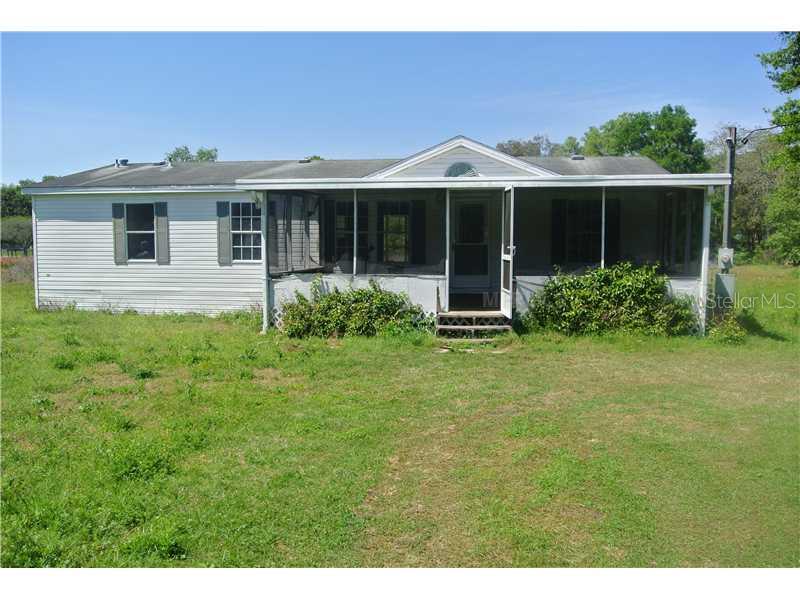 7541 Forbes Road Zephyrhills, FL 33540 - Photo 1 of 1 a house with green field in front of it