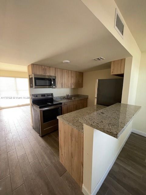 1680 Northwest 4th Avenue, Unit 8B Miami, FL 33136 - Photo 7 of 9 a kitchen with stainless steel appliances a sink a stove top oven a counter space and cabinets
