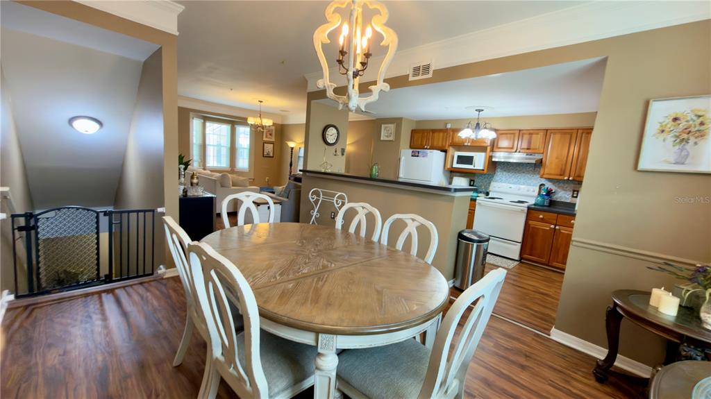 6624 Time Square Avenue, Unit 102 Orlando, FL 32835 - Photo 14 of 96 a view of a dining room with furniture a chandelier and wooden floor