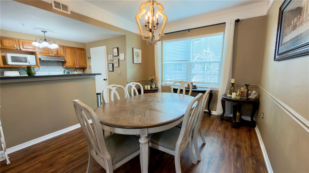 6624 Time Square Avenue, Unit 102 Orlando, FL 32835 - Photo 18 of 96 a dining room with furniture a chandelier and wooden floor