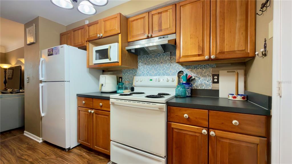 6624 Time Square Avenue, Unit 102 Orlando, FL 32835 - Photo 36 of 96 a kitchen with stainless steel appliances granite countertop a refrigerator a sink dishwasher and wooden cabinets
