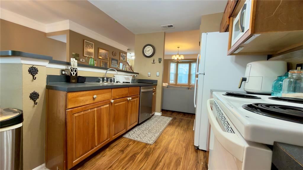 6624 Time Square Avenue, Unit 102 Orlando, FL 32835 - Photo 37 of 96 a kitchen with stainless steel appliances granite countertop a stove a sink and a refrigerator