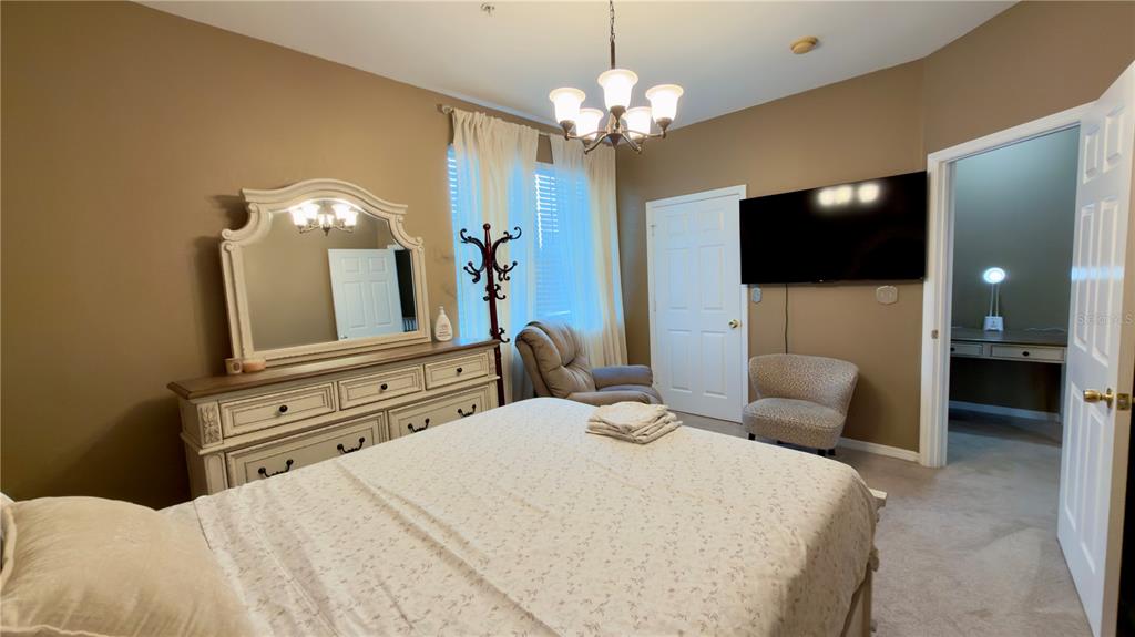 6624 Time Square Avenue, Unit 102 Orlando, FL 32835 - Photo 54 of 96 a bedroom with a bed and a flat screen tv