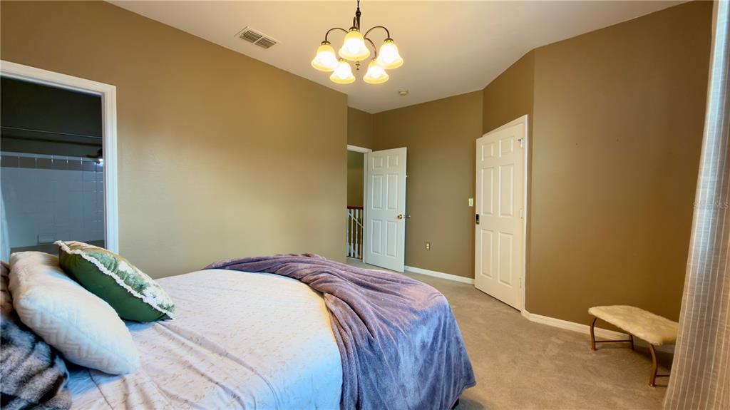 6624 Time Square Avenue, Unit 102 Orlando, FL 32835 - Photo 66 of 96 a bedroom with a bed and a chandelier