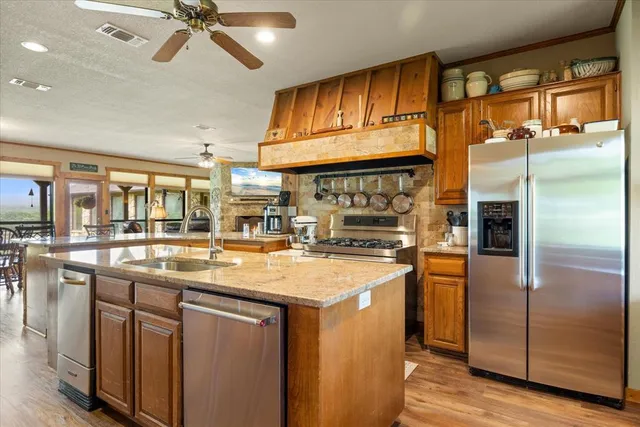a kitchen with stainless steel appliances granite countertop a sink and cabinets