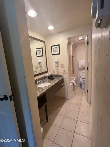 a spacious bathroom with a sink a toilet and a mirror