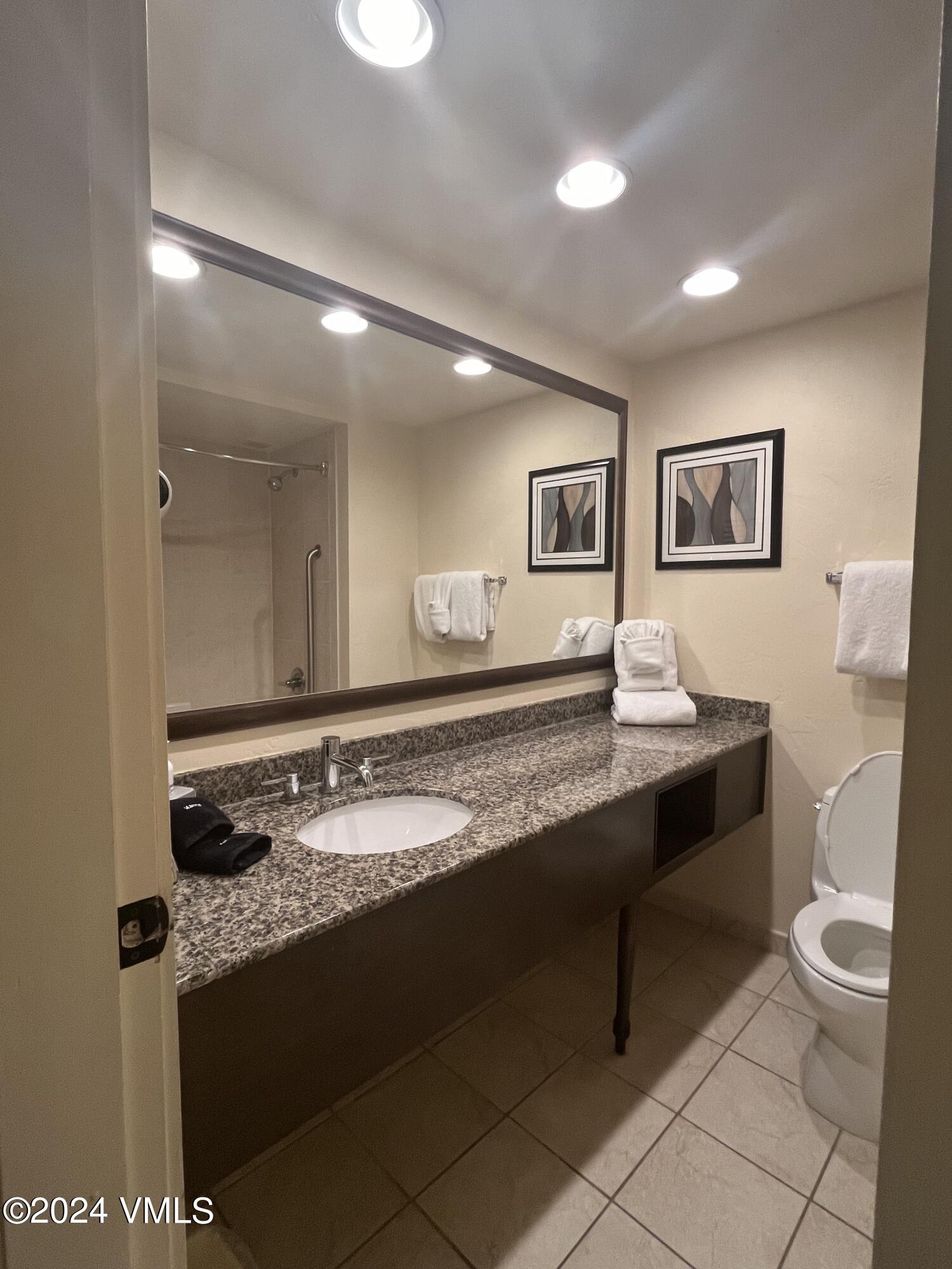 1020 Vail View Drive, Unit 120412 Vail, CO 81657 - Photo 10 of 23 a spacious bathroom with a granite countertop sink a toilet a mirror and vanity