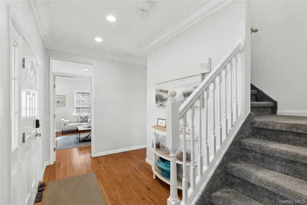 a view of staircase with white walls and wooden floor