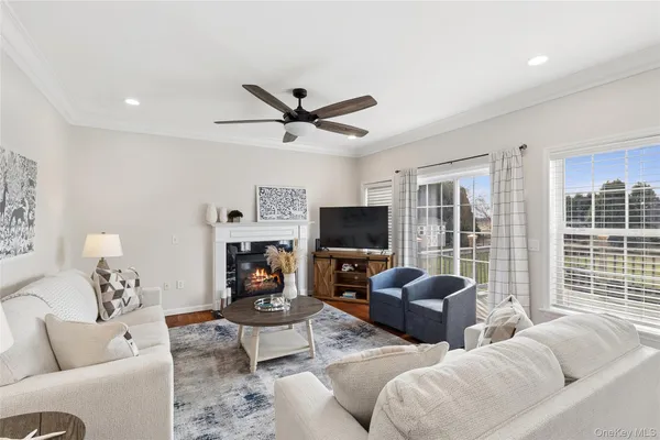 a living room with furniture a flat screen tv and a fireplace