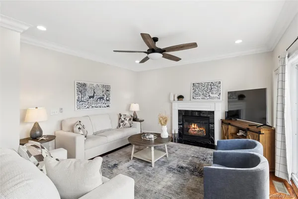 a living room with furniture a flat screen tv and a fireplace