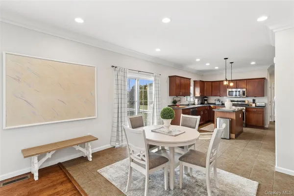 a kitchen with a dining table chairs and refrigerator