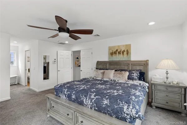 a bedroom with a bed and a lamp on dresser