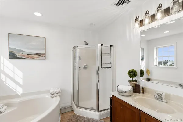 a bathroom with a tub sink and mirror