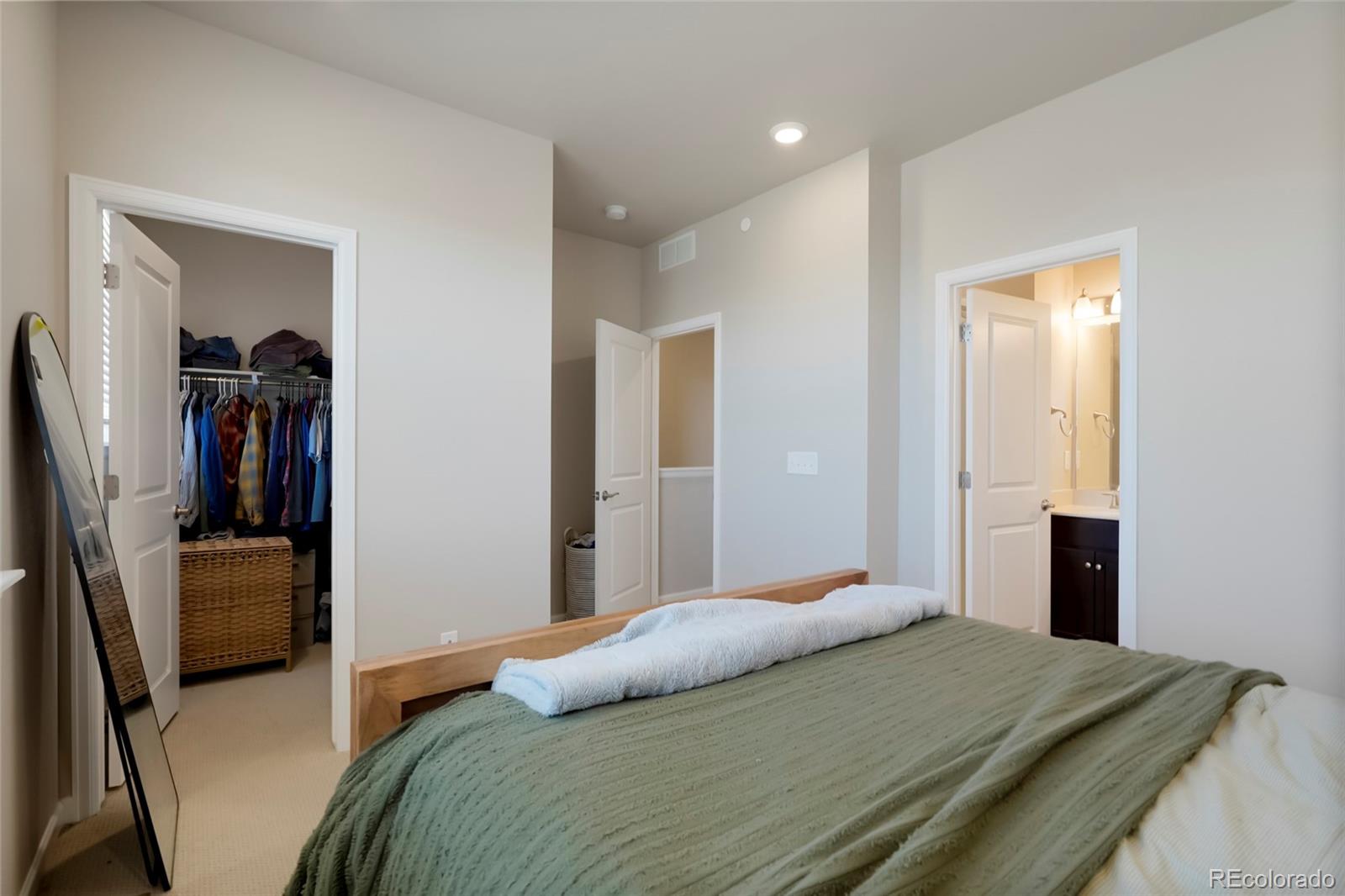 6974 Merseyside Lane Castle Pines, CO 80108 - Photo 18 of 27 a bedroom with a bed and a view of bathroom