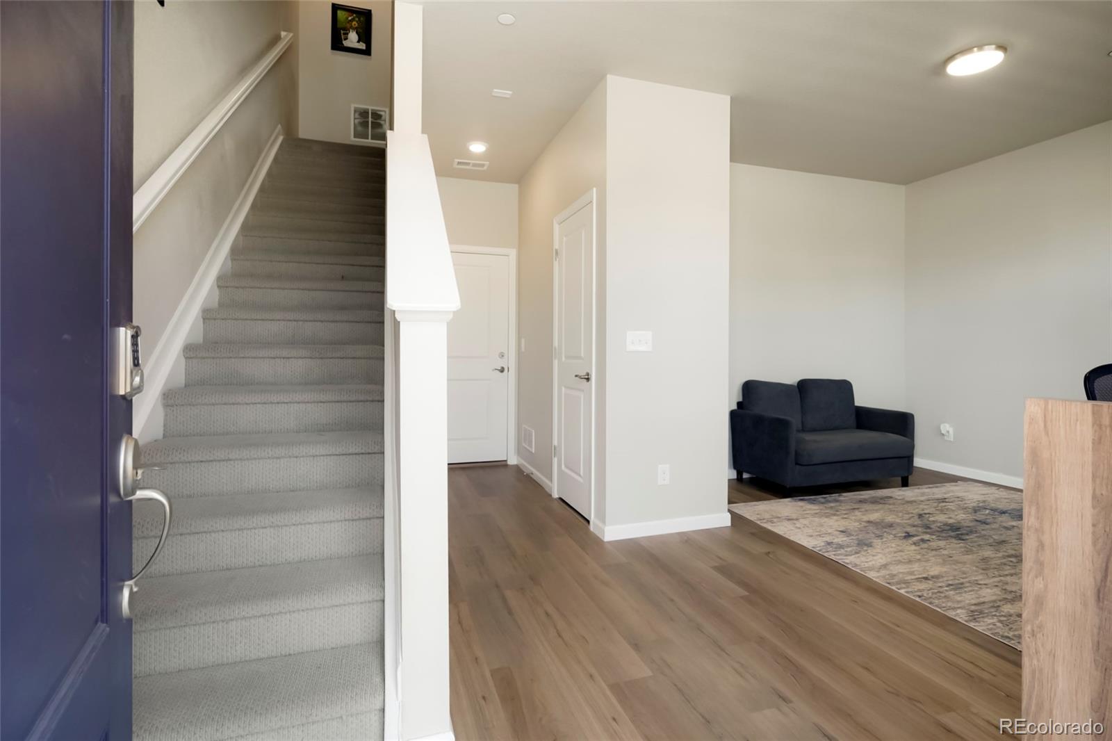 6974 Merseyside Lane Castle Pines, CO 80108 - Photo 3 of 27 a view of a hallway with wooden floor and staircase
