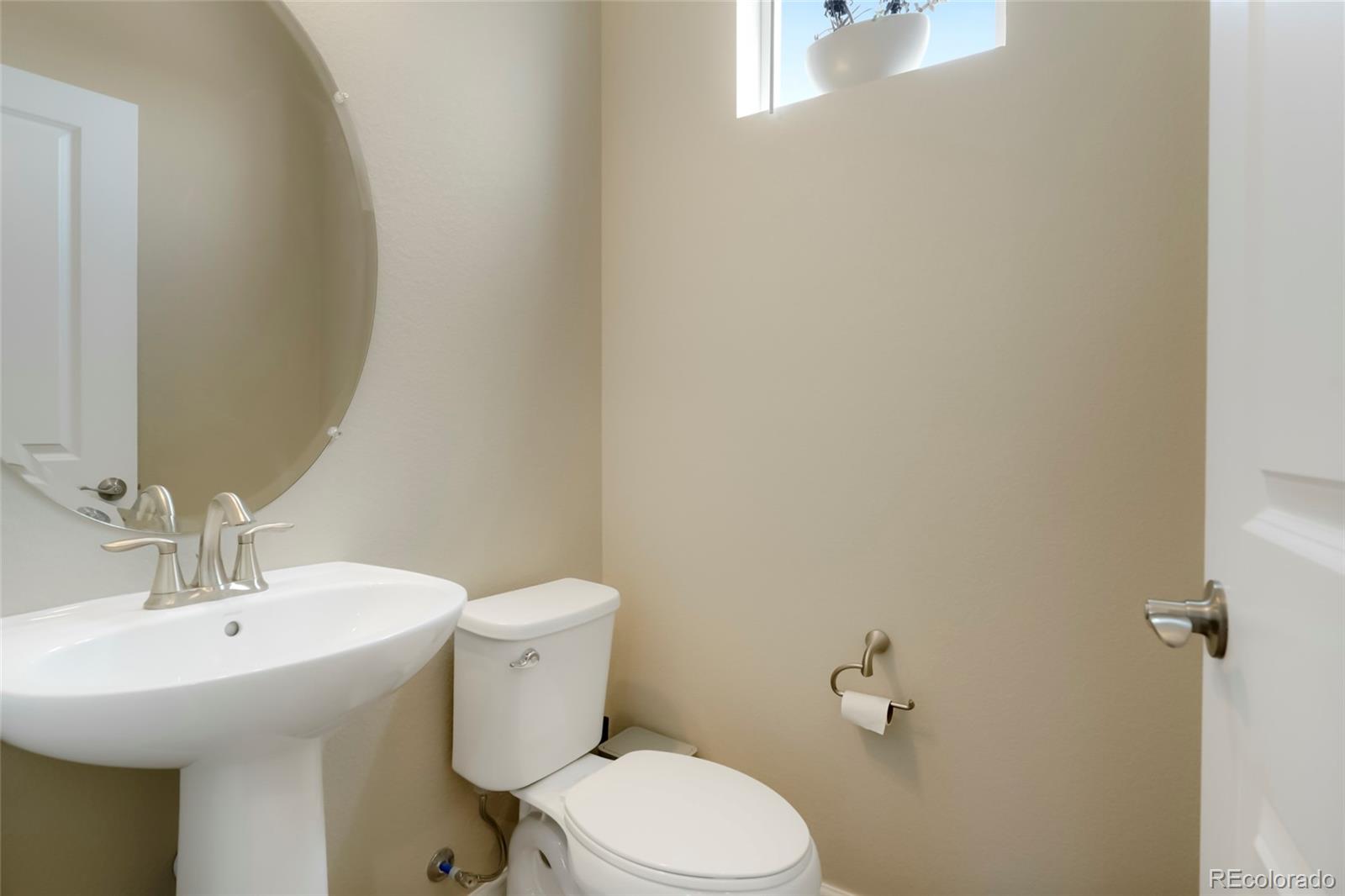 6974 Merseyside Lane Castle Pines, CO 80108 - Photo 5 of 27 a bathroom with a sink a toilet and a mirror