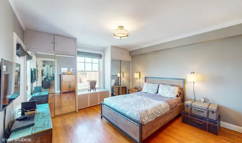 a bedroom with a bed and wooden floor