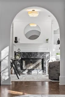 a living room with furniture a mirror and a fireplace