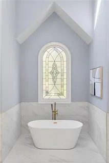 a view of a hallway to a livingroom with wooden floor and stairs