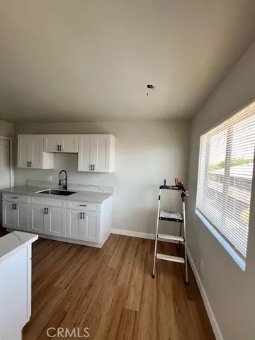 a kitchen with a sink and wooden floor