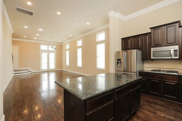 a kitchen with stainless steel appliances granite countertop a sink a stove and a refrigerator