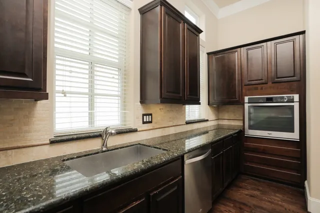 a kitchen with granite countertop stainless steel appliances a sink and a window