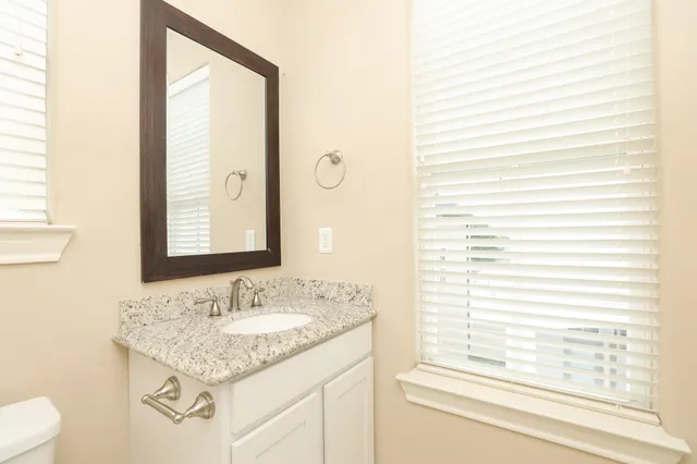 a bathroom with a granite countertop sink and a mirror