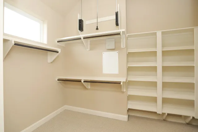 a view of walk in closet with empty racks