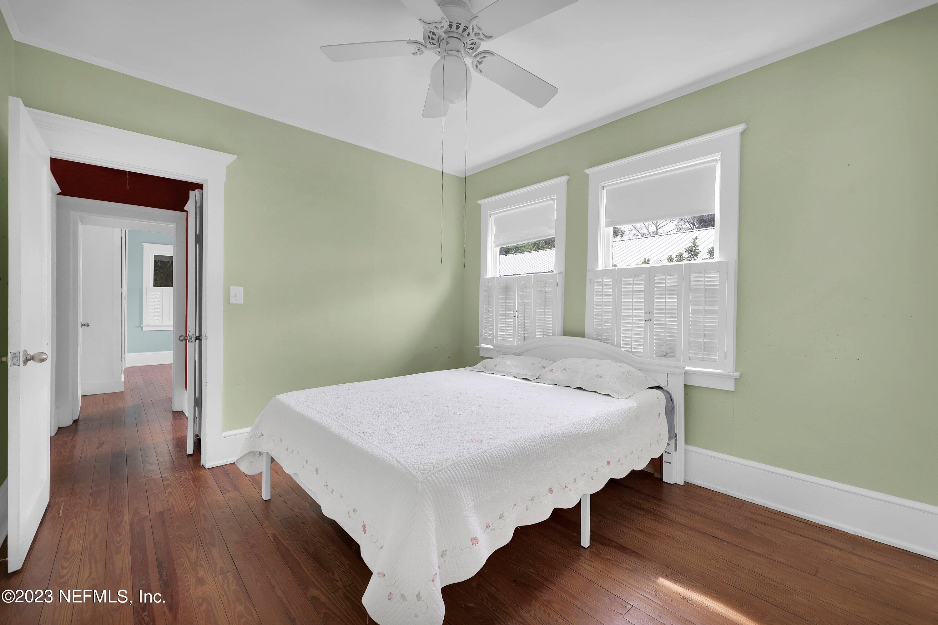 4 Florida Avenue St. Augustine, FL 32084 - Photo 17 of 52 a bedroom with a bed and a chandelier