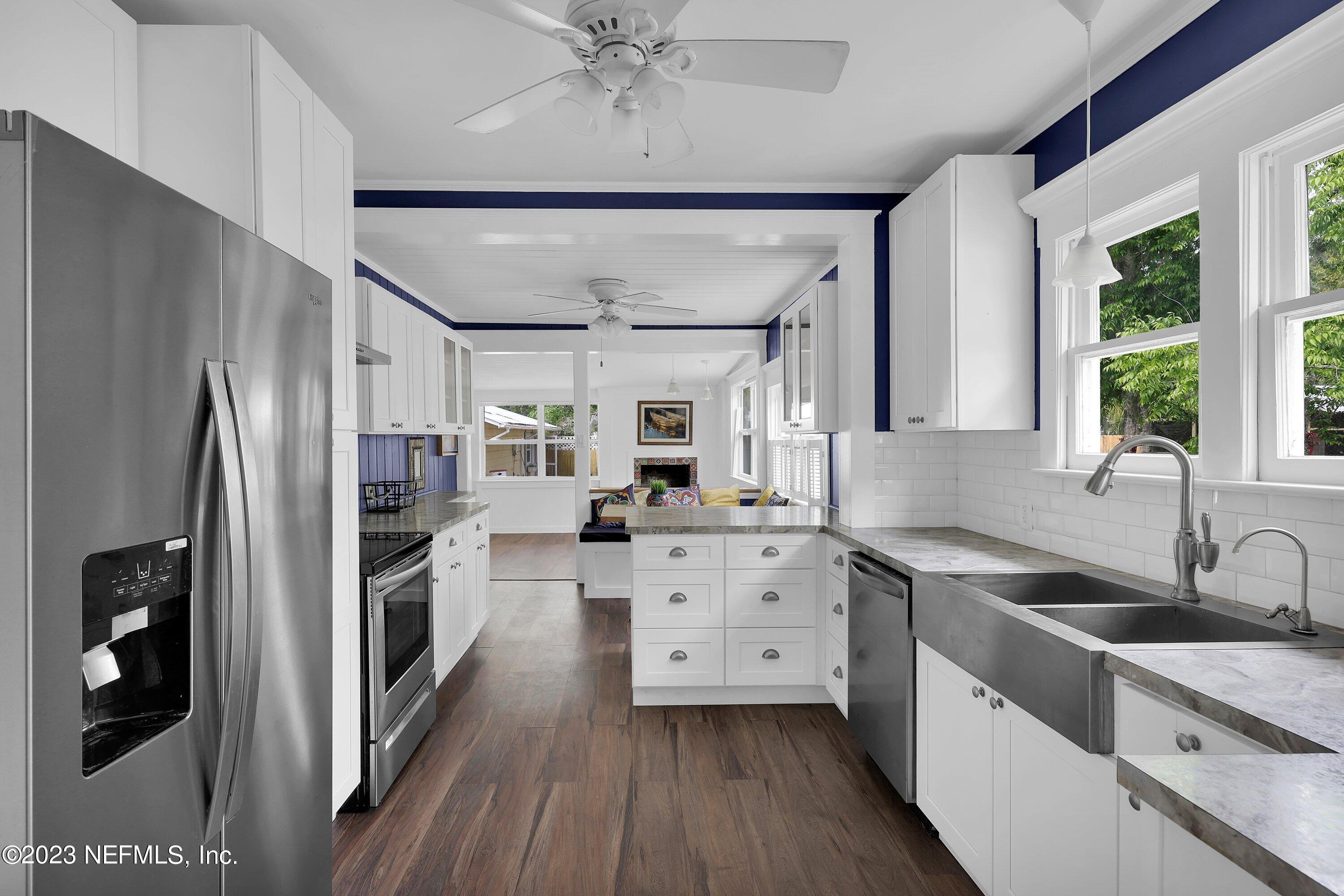 4 Florida Avenue St. Augustine, FL 32084 - Photo 5 of 52 a kitchen with white cabinets and stainless steel appliances