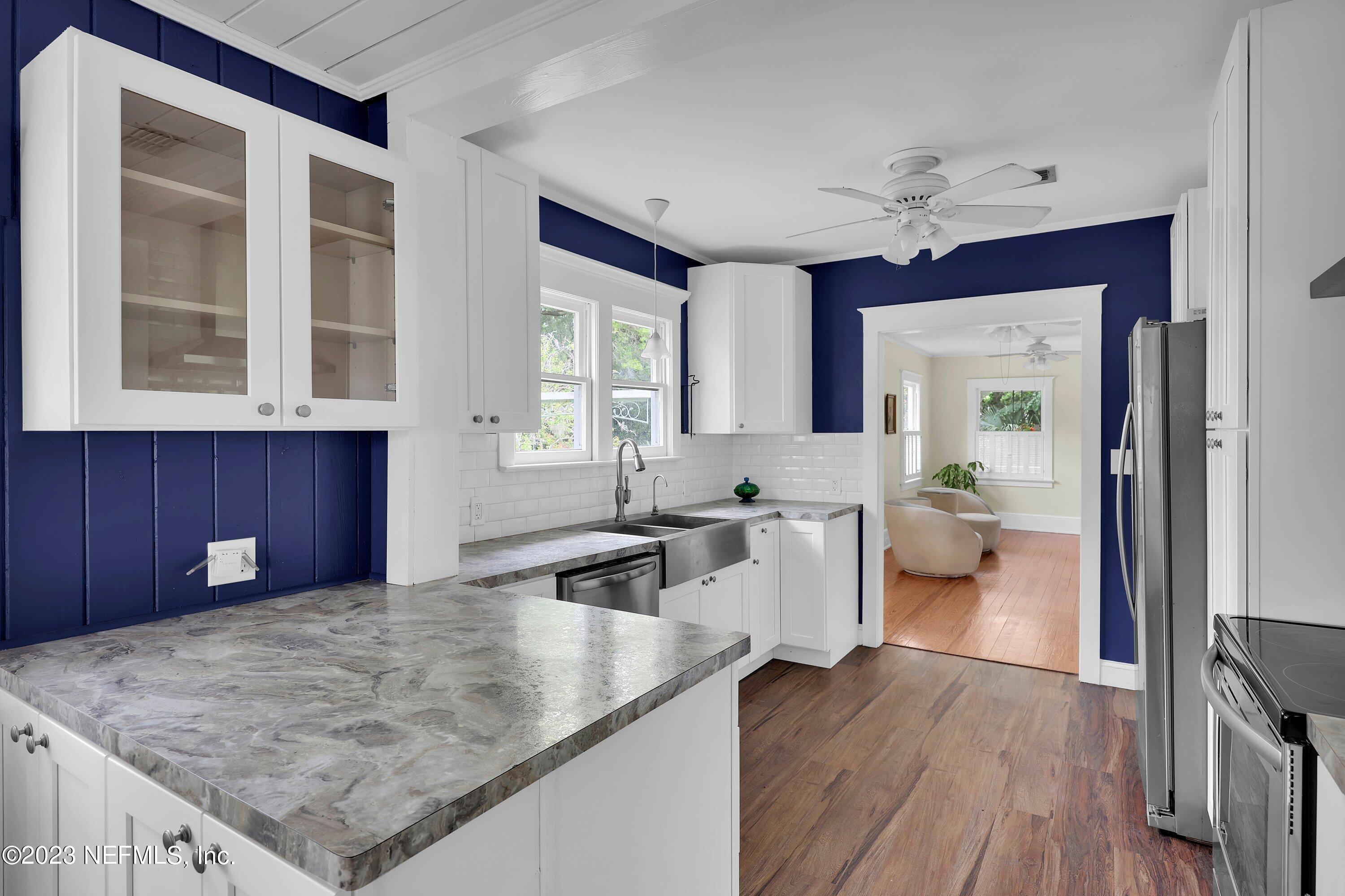 4 Florida Avenue St. Augustine, FL 32084 - Photo 8 of 52 a kitchen with a wooden floor and a large window