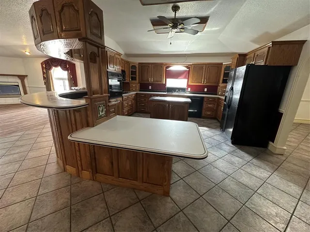 a kitchen with stainless steel appliances granite countertop a stove a refrigerator a sink a microwave and dining table