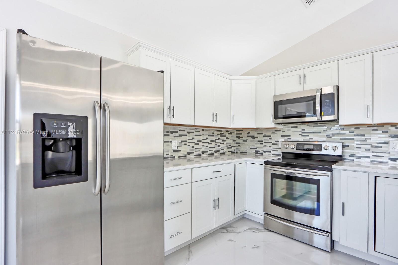 112 Raintree Trail Jupiter, FL 33458 - Photo 15 of 37 a kitchen with cabinets stainless steel appliances and counter space