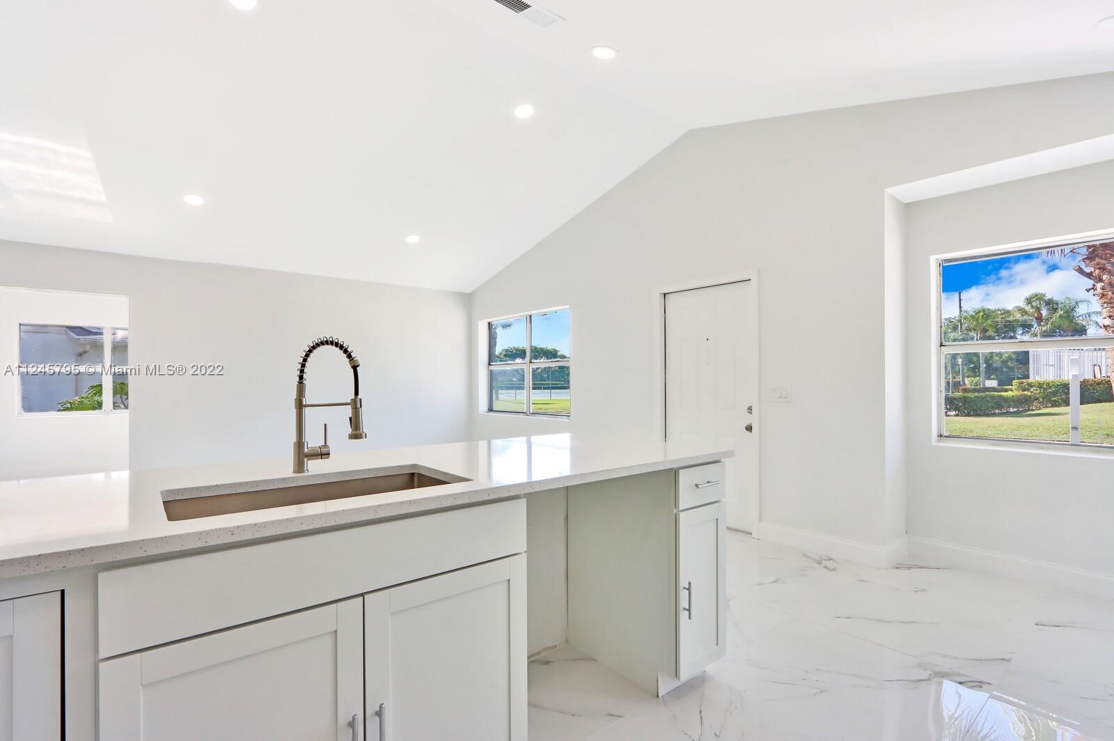 112 Raintree Trail Jupiter, FL 33458 - Photo 19 of 37 a kitchen with a sink and cabinets