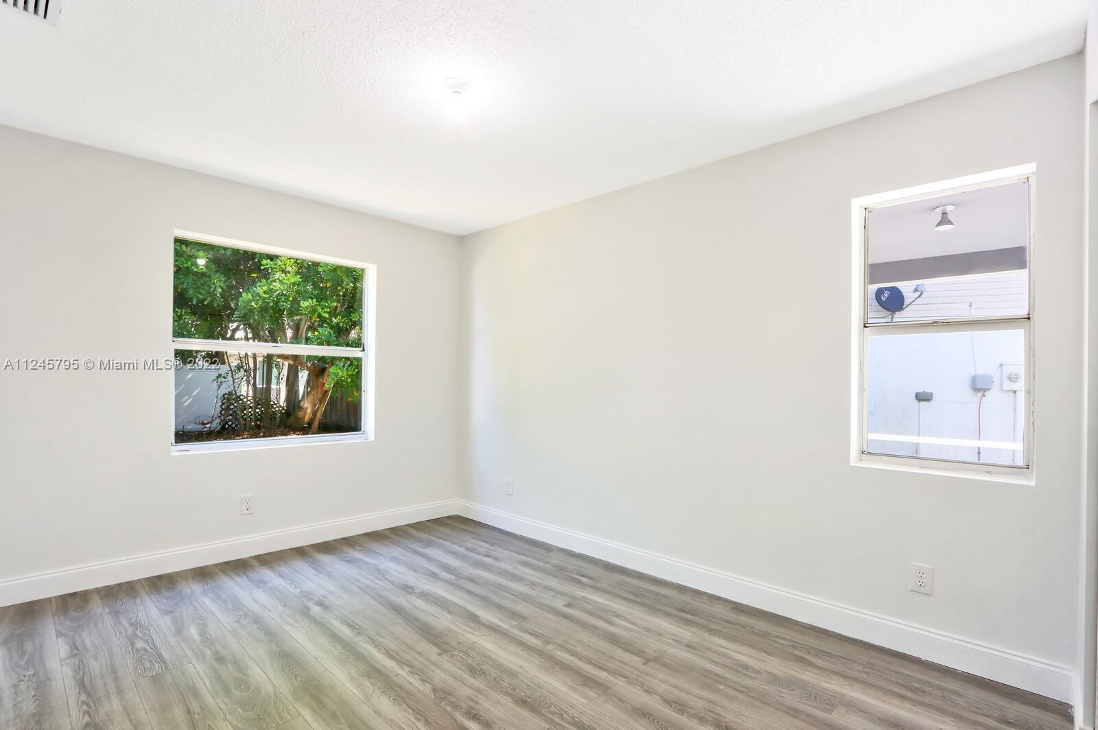 112 Raintree Trail Jupiter, FL 33458 - Photo 26 of 37 an empty room with wooden floor and windows