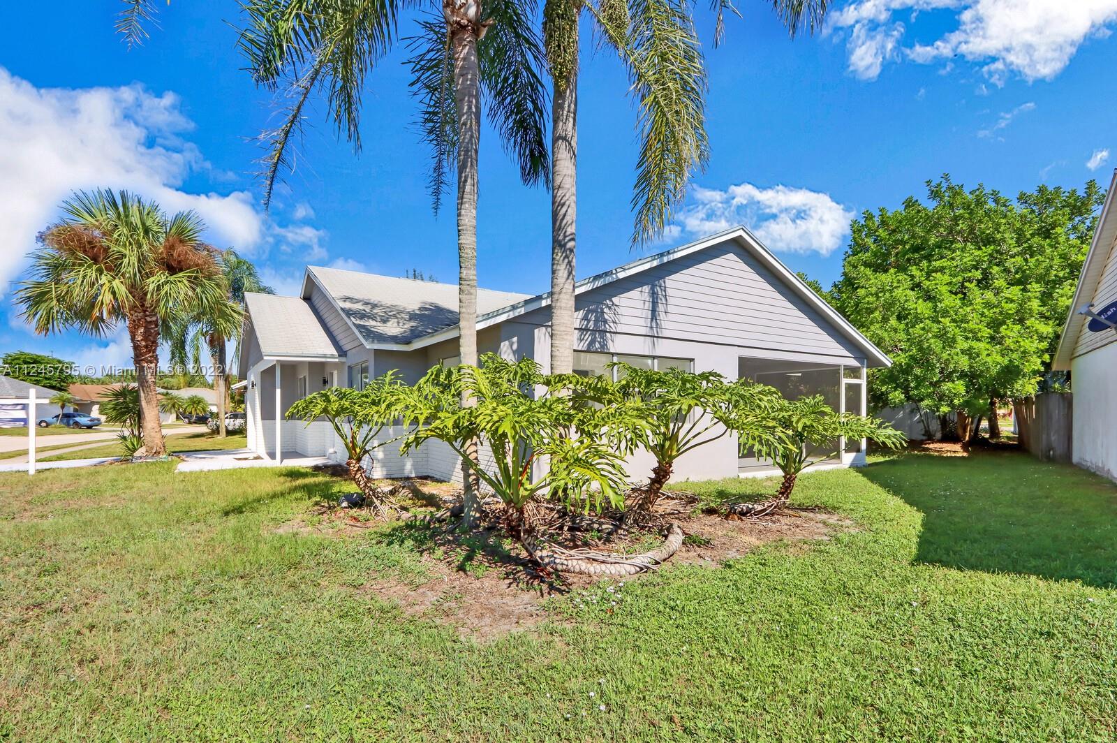112 Raintree Trail Jupiter, FL 33458 - Photo 4 of 37 a view of a backyard with plants and a patio