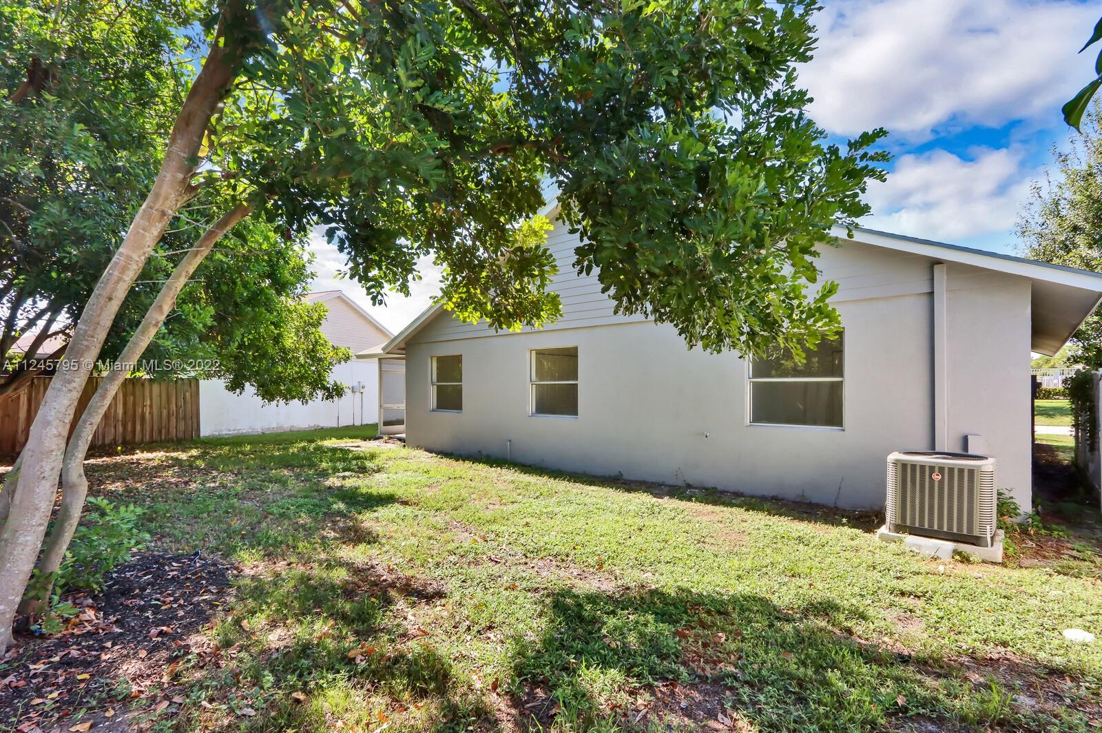 112 Raintree Trail Jupiter, FL 33458 - Photo 5 of 37 a backyard of a house with plants and large tree