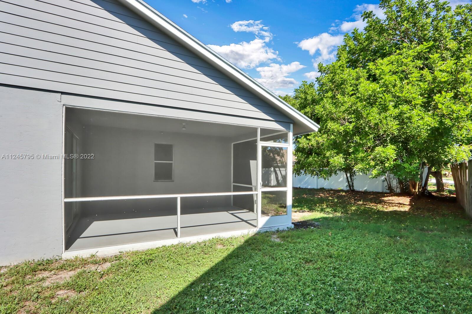 112 Raintree Trail Jupiter, FL 33458 - Photo 6 of 37 a backyard of a house with plants and large tree