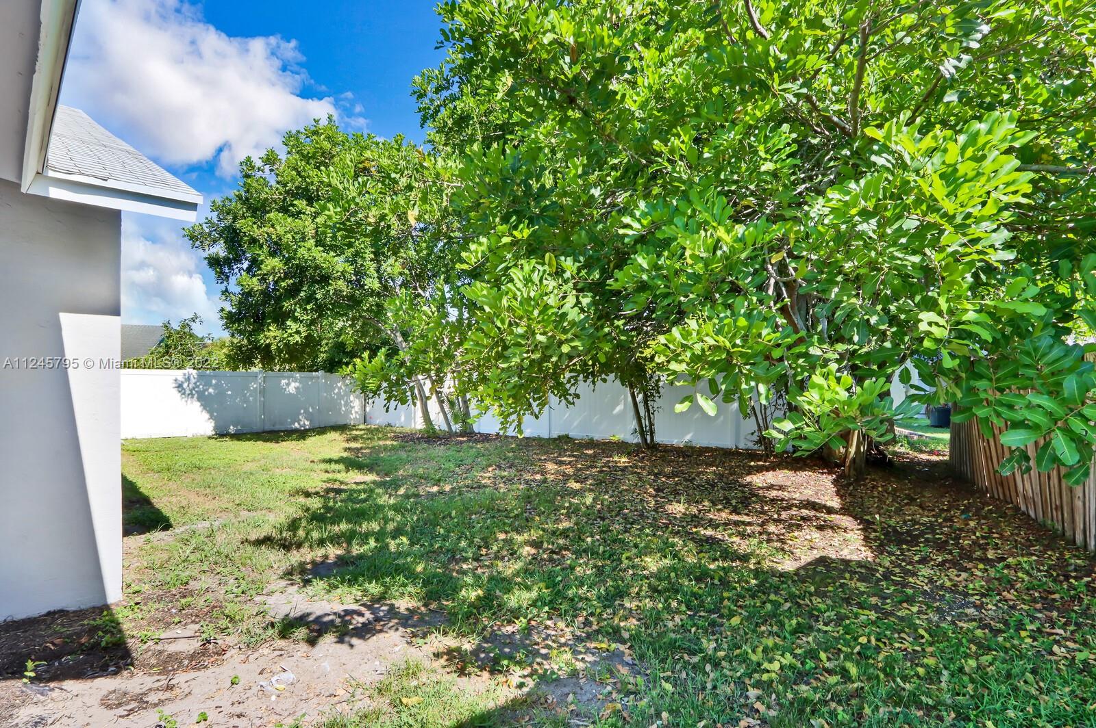 112 Raintree Trail Jupiter, FL 33458 - Photo 8 of 37 a view of a yard with plants and large trees