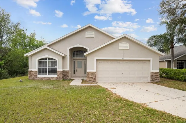 a front view of a house with a yard and garage