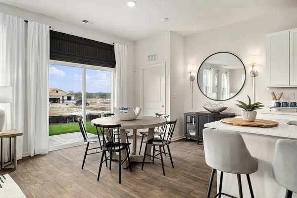 a kitchen with a table chairs sink and cabinets