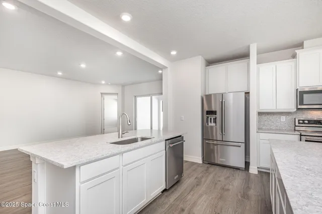 a kitchen with a refrigerator and a sink